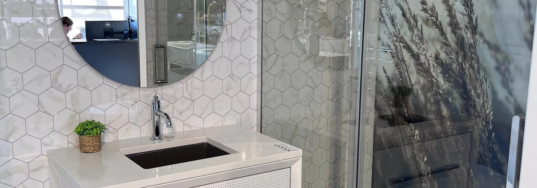 Meuble-lavabo blanc, miroir rond et vitre de douche coulissante